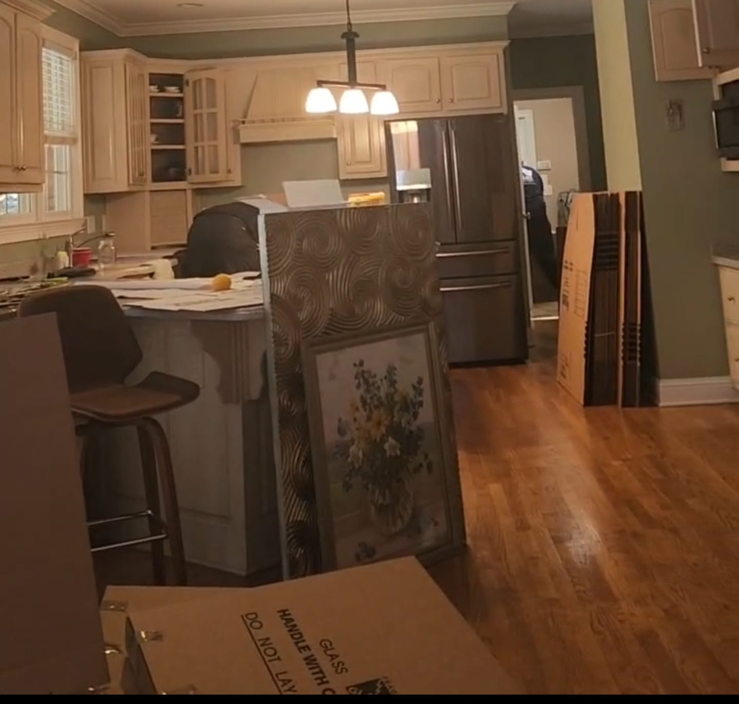 A kitchen with moving boxes and framed art ready to pack