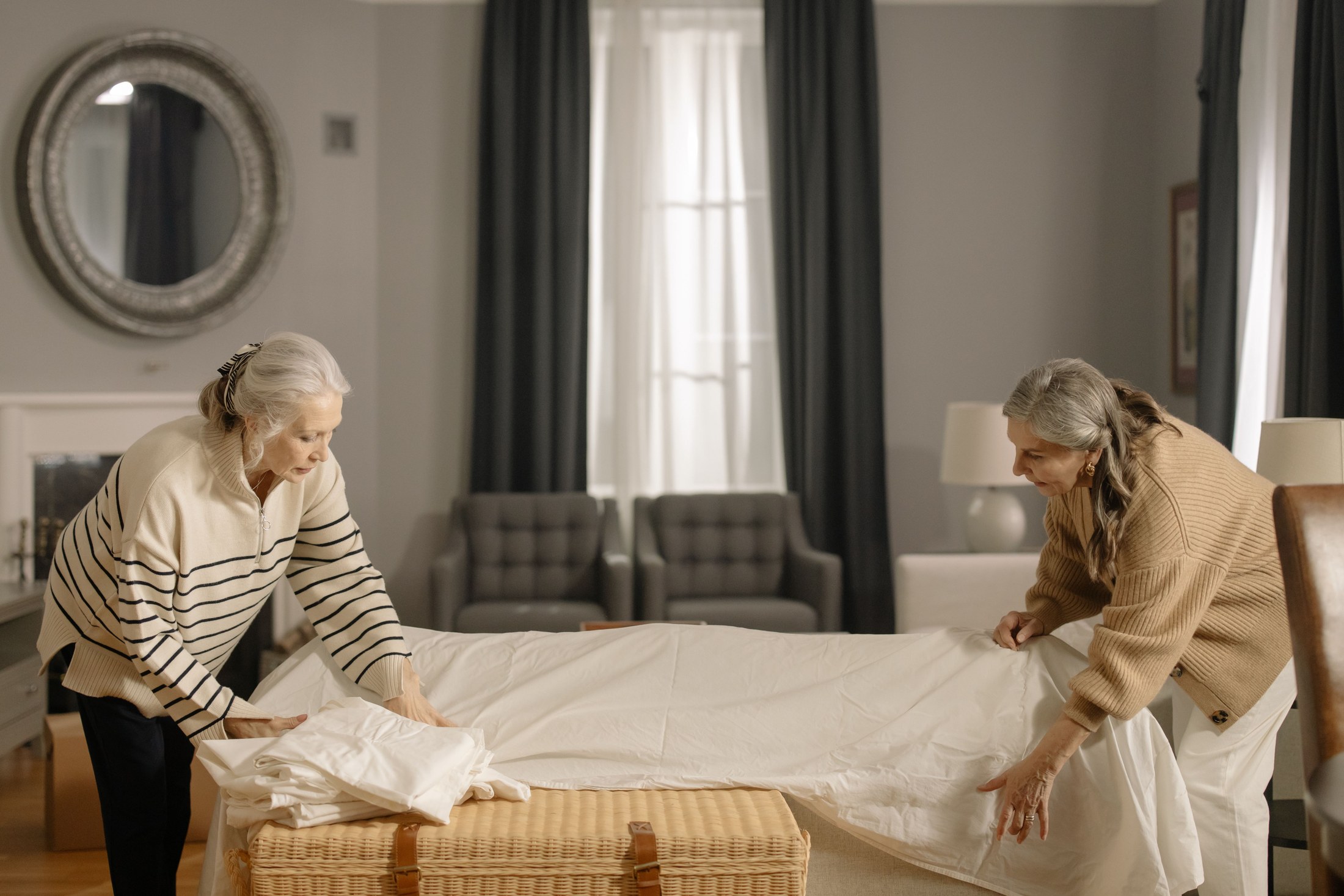 Two women sorting and folding household linens together